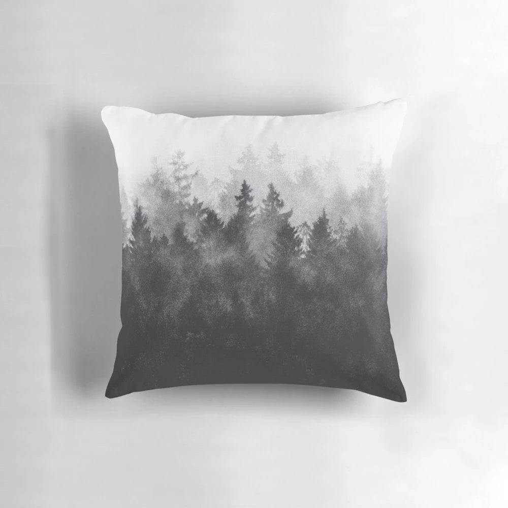 Pillow featuring a watercolor painting of a misty, foggy forest with trees and mountains.