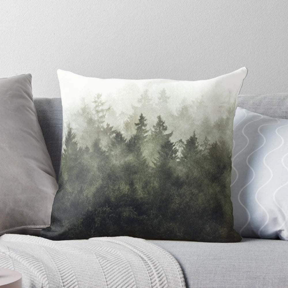 A cozy pillow featuring a dreamy, moody forest landscape with trees covered in magical fog, evoking a sense of tranquility and adventure.