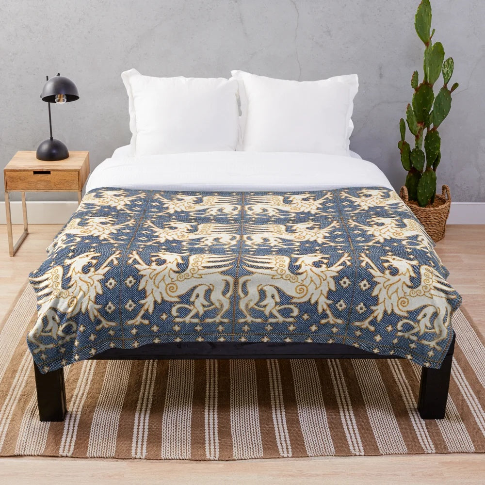 Plush blanket featuring a design of gold white gryphons on a blue background