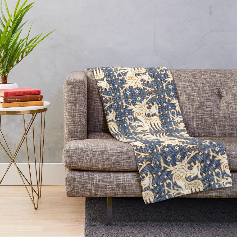Plush blanket featuring a design of gold white gryphons on a blue background
