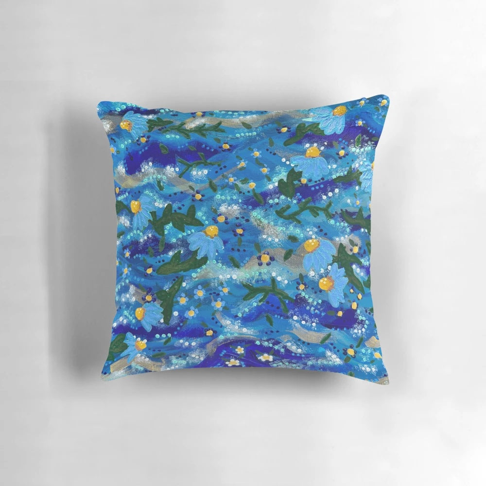 Vibrant hand-painted flowers floating on a blue background, creating a serene and captivating pillow design.