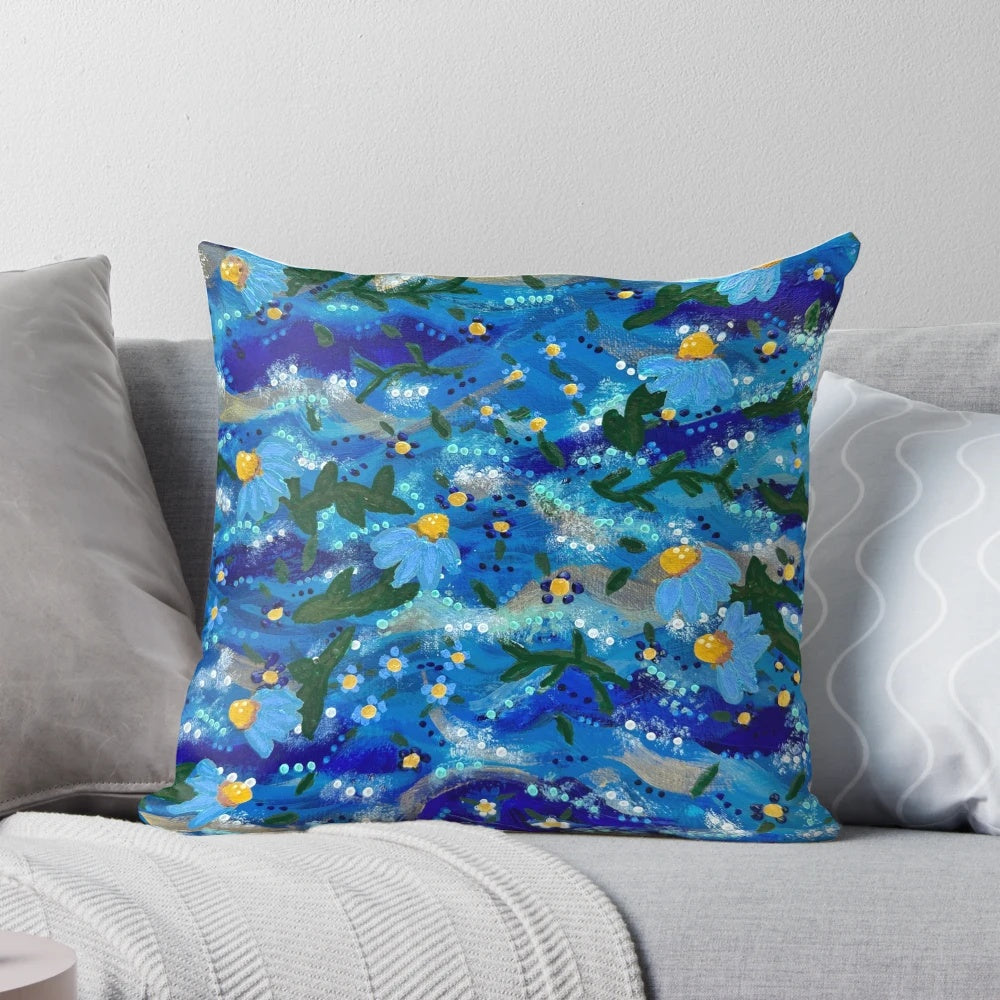 Vibrant hand-painted flowers floating on a blue background, creating a serene and captivating pillow design.