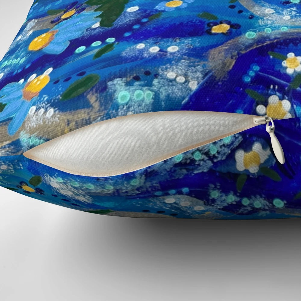 Vibrant hand-painted flowers floating on a blue background, creating a serene and captivating pillow design.