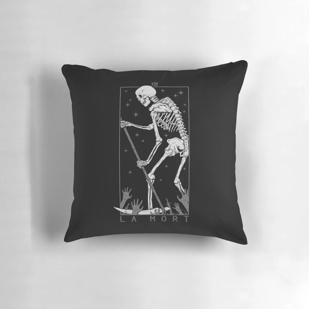 A black and white pillow featuring a macabre skull and tarot card imagery for a gothic, occult-inspired home.