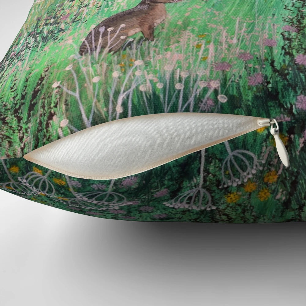 A beautiful pillow featuring a serene meadow landscape with hares and wildlife, designed by artist Jo Grundy.