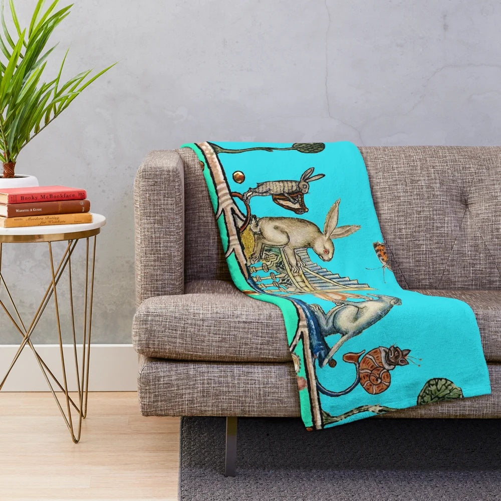 A cozy plush blanket featuring whimsical medieval bestiary animals playing musical instruments like a white rabbit and dog on an organ, a harpist hare, and a snail cat.