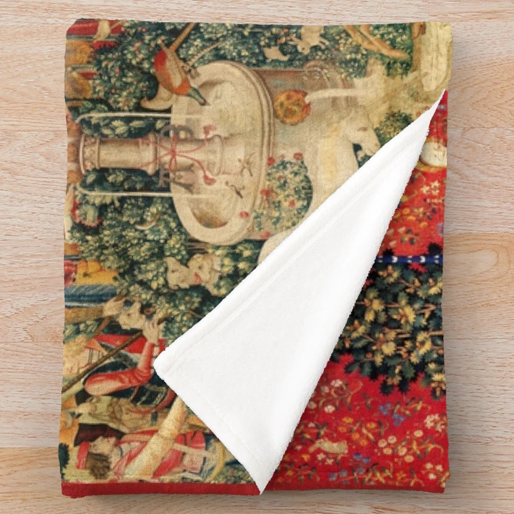 Plush blanket featuring a medieval-style illustration of a unicorn and ladies in a fantasy floral garden