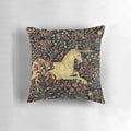 Decorative medieval-style pillow featuring a mythical unicorn surrounded by a lush black floral tapestry design.