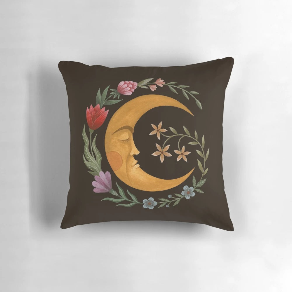 A decorative pillow featuring a beautiful moon and floral design, perfect for a cozy and serene bedroom.