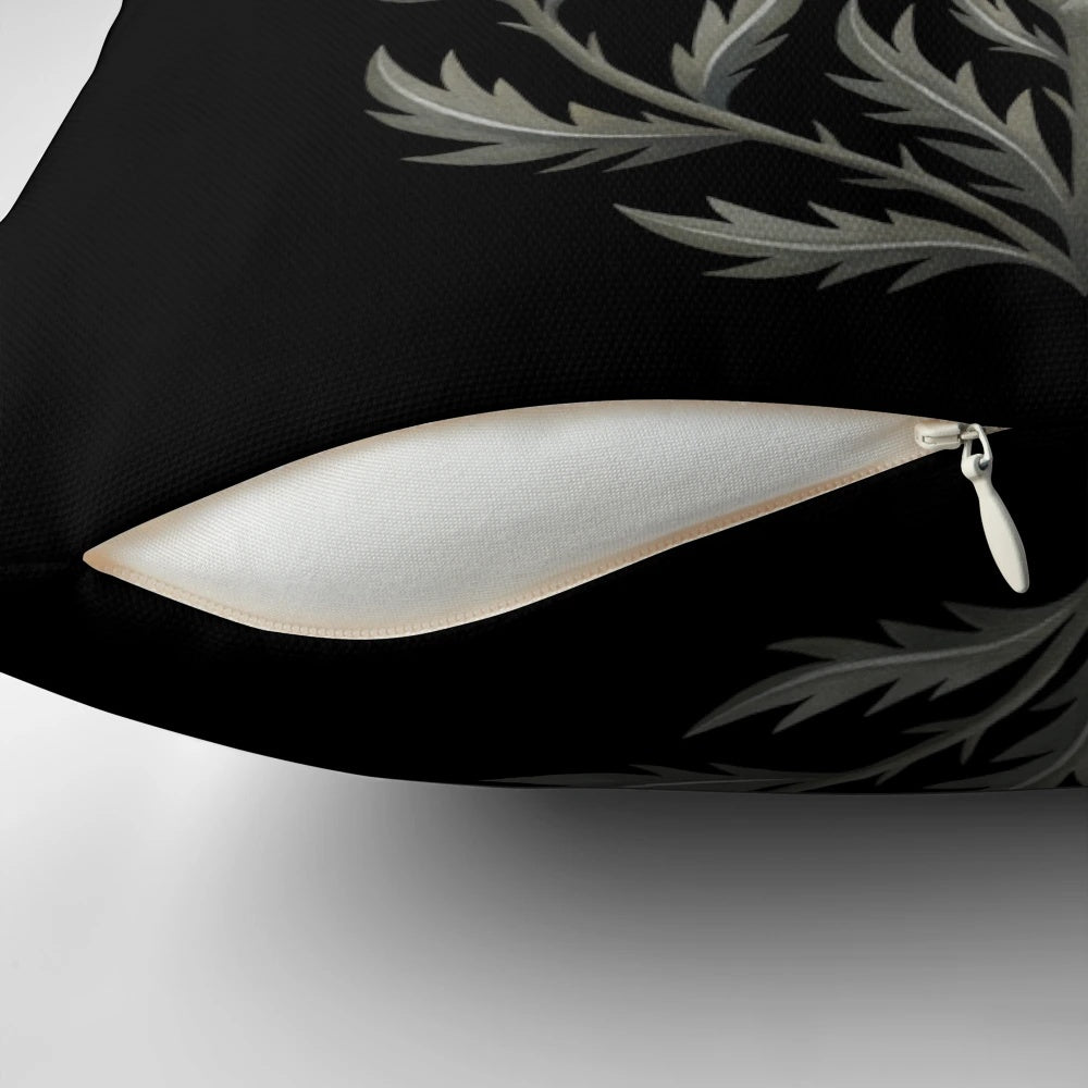 Decorative pillow featuring a moth and thistle design against a crescent moon backdrop
