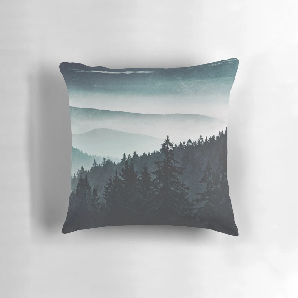 A cozy mountain light pillow with a serene, misty forest landscape design
