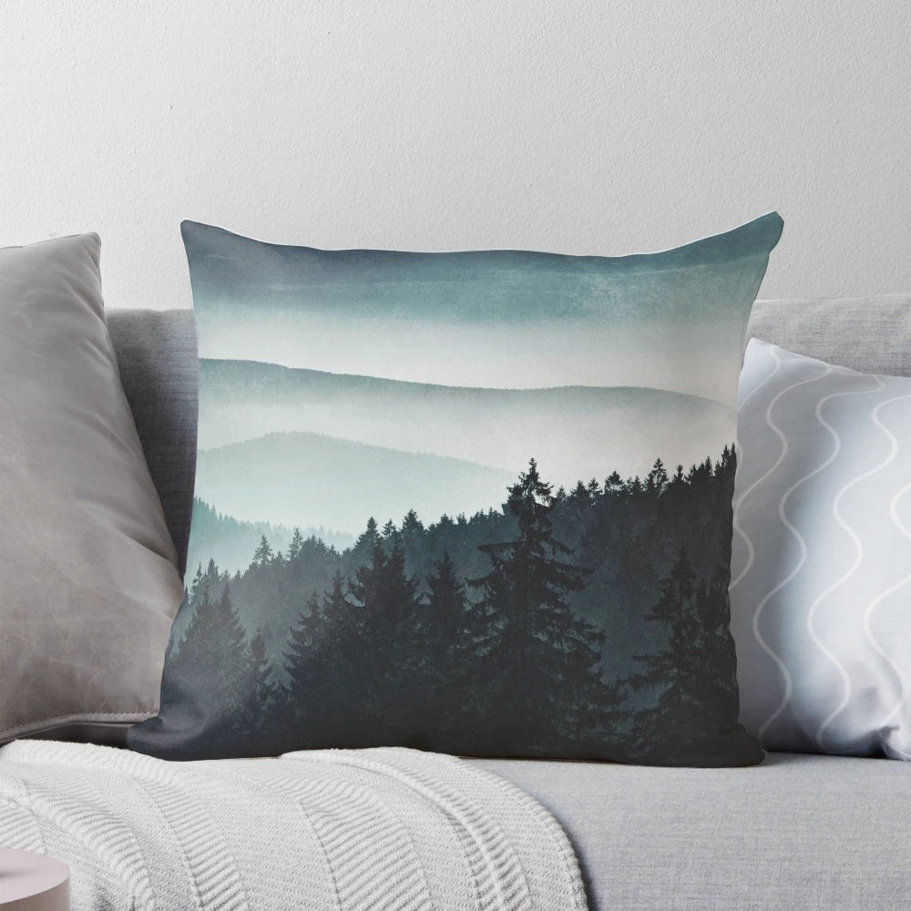 A cozy mountain light pillow with a serene, misty forest landscape design