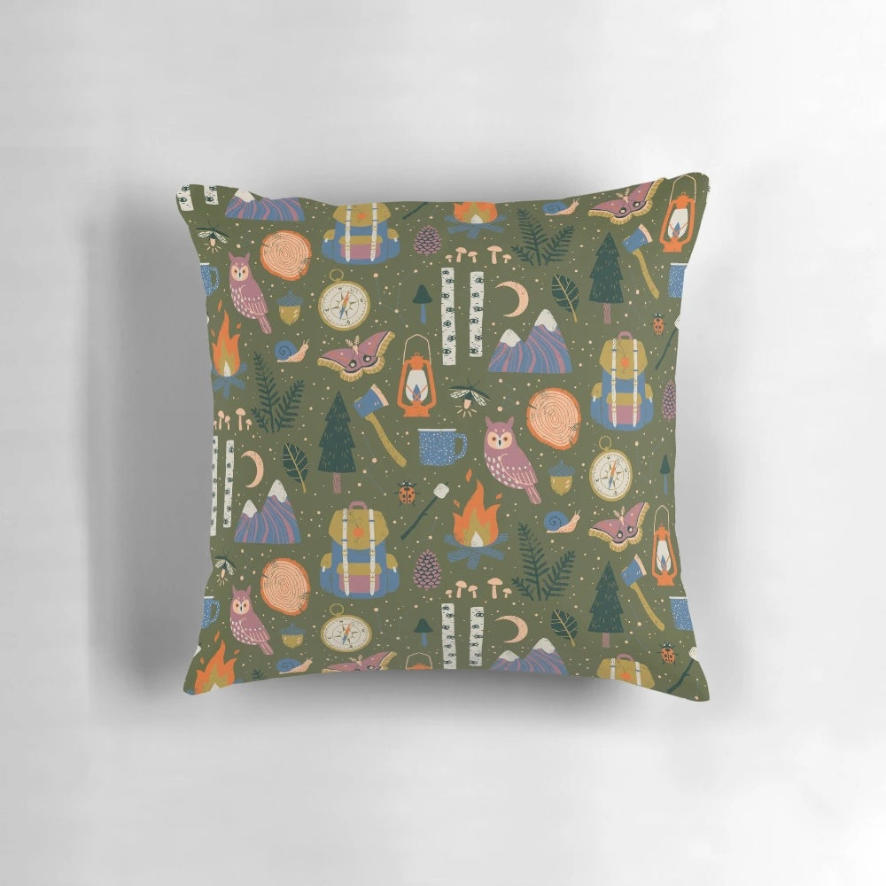 A nature-inspired pillow with a forest design, featuring owls, campfires, and wanderlust elements.