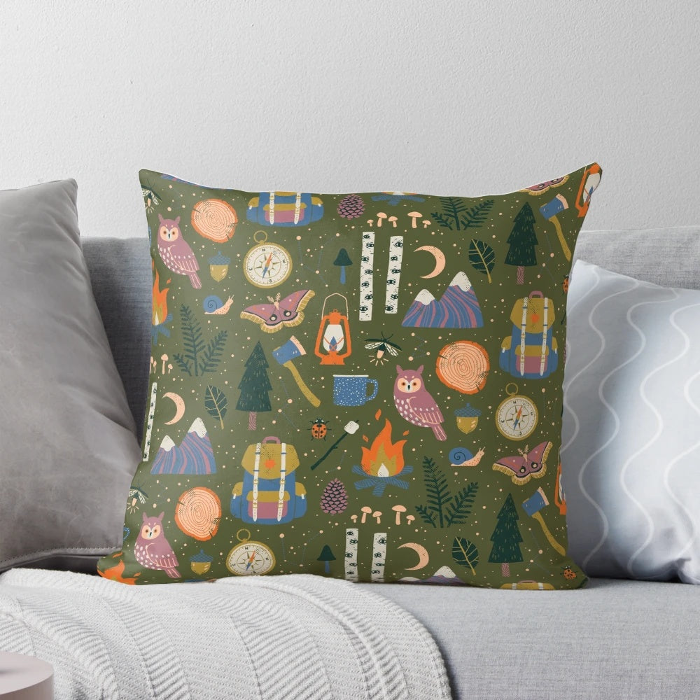 A nature-inspired pillow with a forest design, featuring owls, campfires, and wanderlust elements.