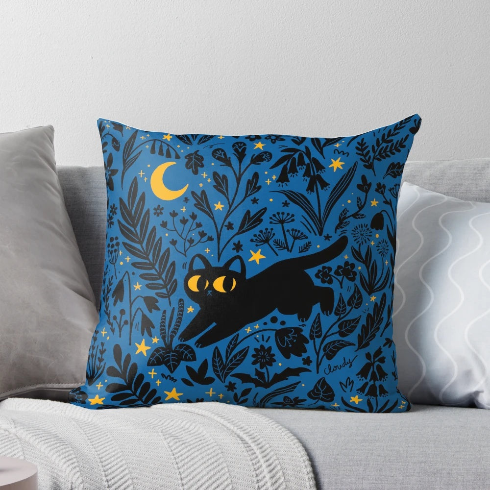 Decorative throw pillow with a whimsical night sky and botanical design featuring a black cat