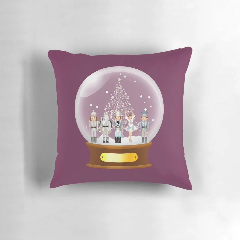 A cozy Christmas pillow featuring a snow globe with a nutcracker ballet scene, perfect for holiday decor.