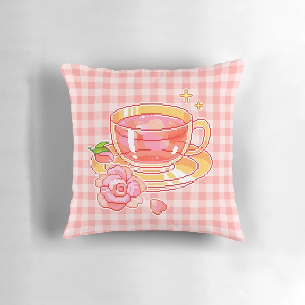 A delightful pixel tea-themed pillow with a pink and floral design, perfect for adding a touch of whimsy to your home decor.