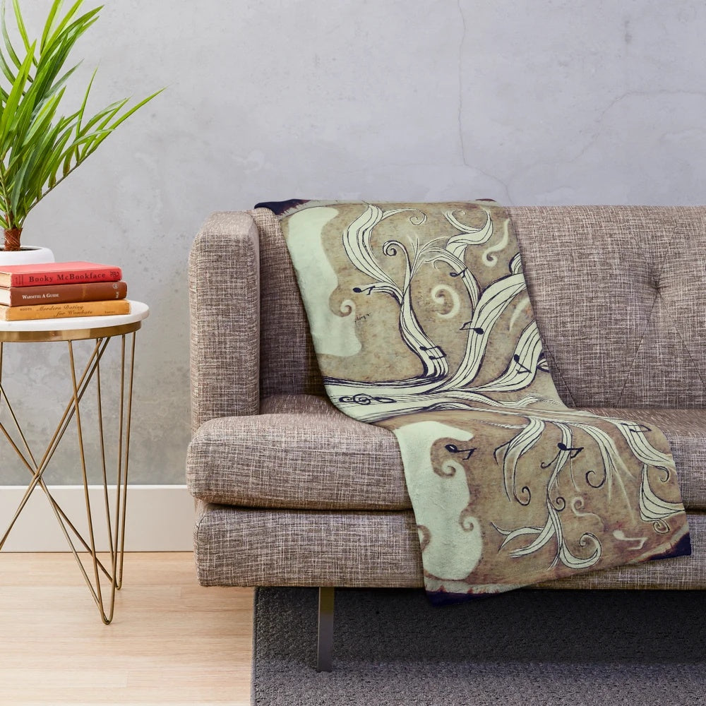 Cozy plush blanket featuring a tree of music design with notes and nature elements