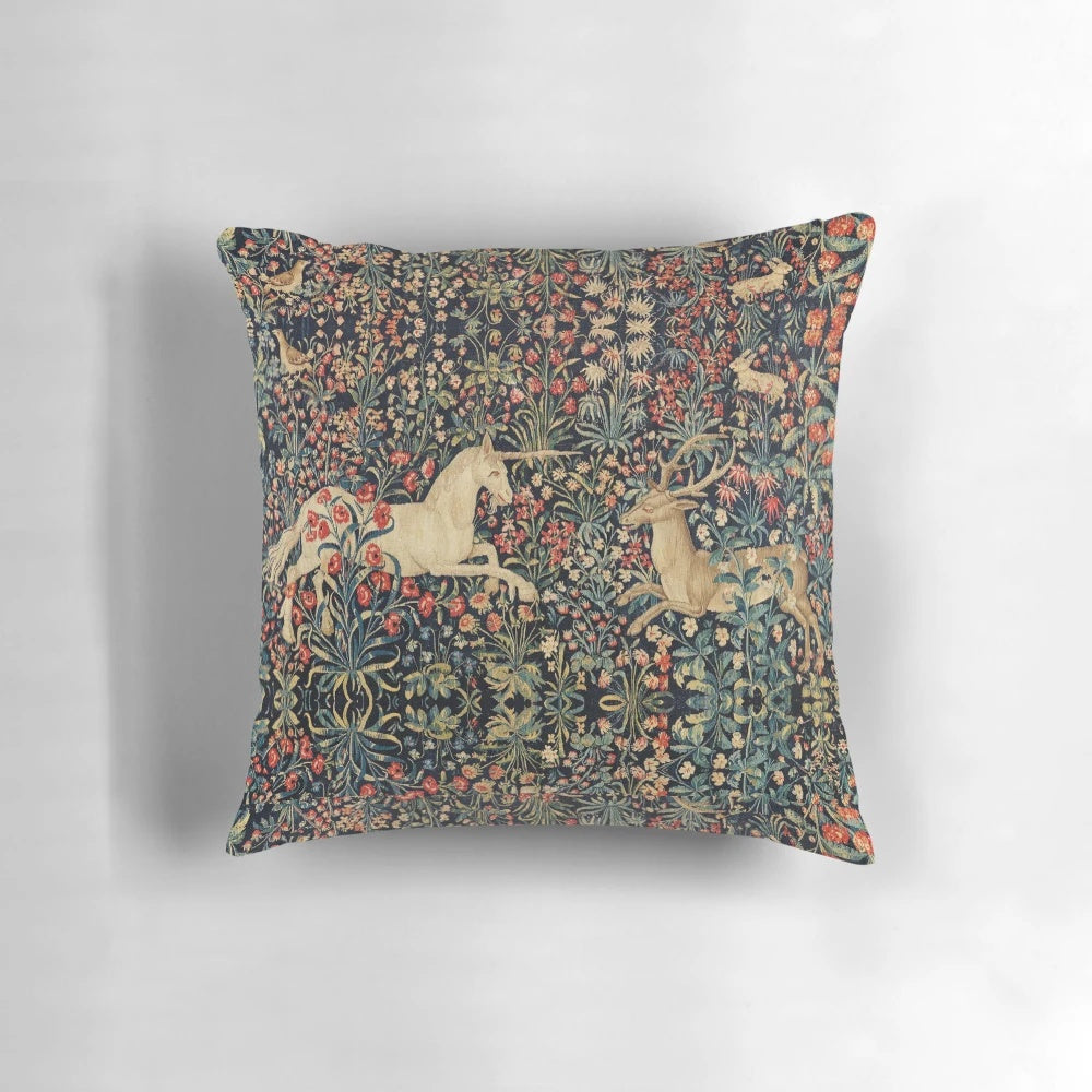 Decorative throw pillow featuring a magical unicorn and deer among a lush, floral forest scene.