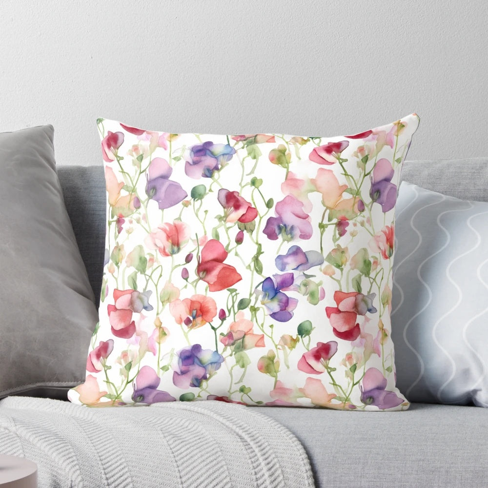 A decorative throw pillow featuring a beautiful watercolor painting of sweet pea flowers.