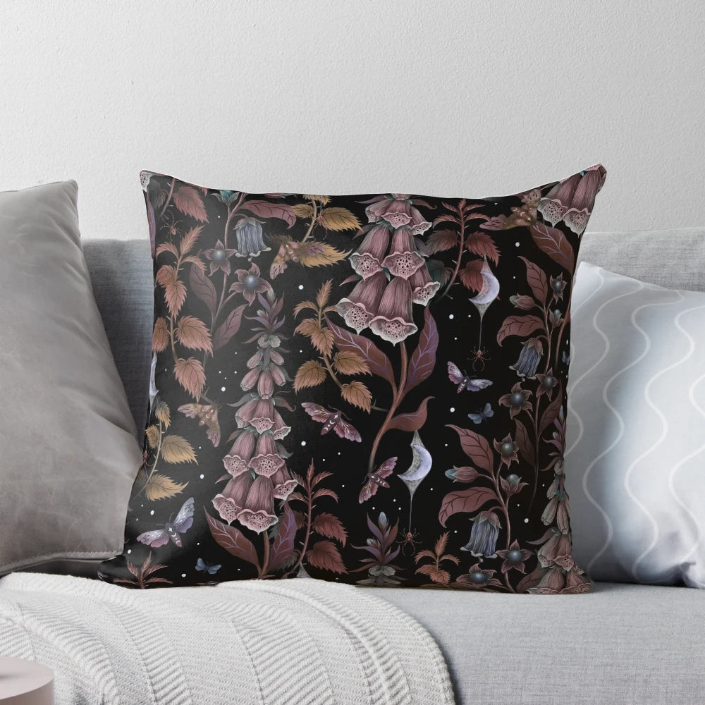 A black and white throw pillow featuring a spooky witch's garden design with a crescent moon, spider web, and haunting gothic elements.