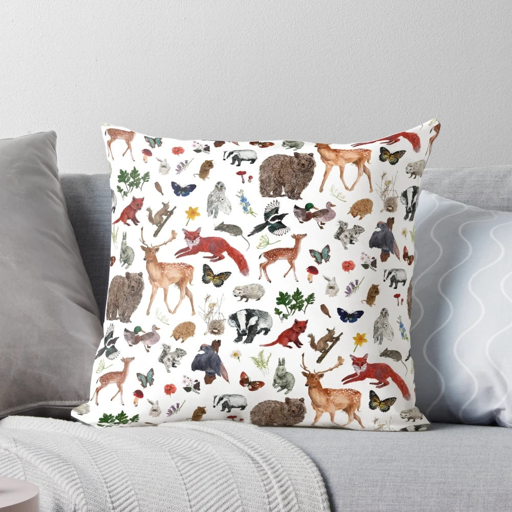 Closeup of a decorative throw pillow featuring various woodland animals like bears, foxes, and deer in a forest scene.