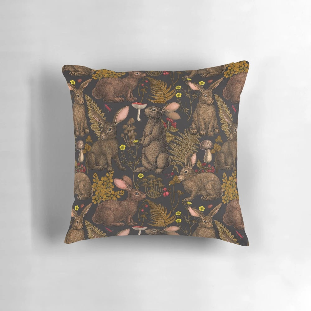 Pillow featuring a whimsical design of rabbits, ferns, and other woodland flora