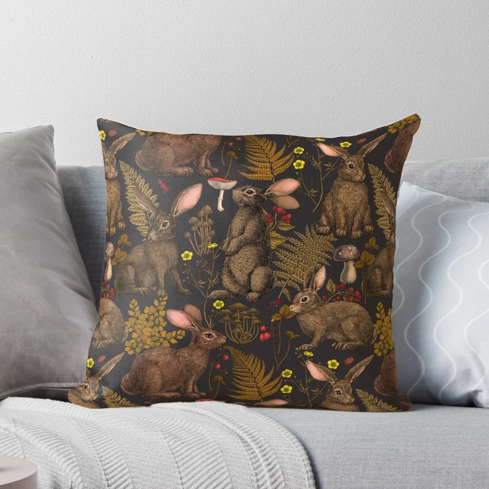 Pillow featuring a whimsical design of rabbits, ferns, and other woodland flora