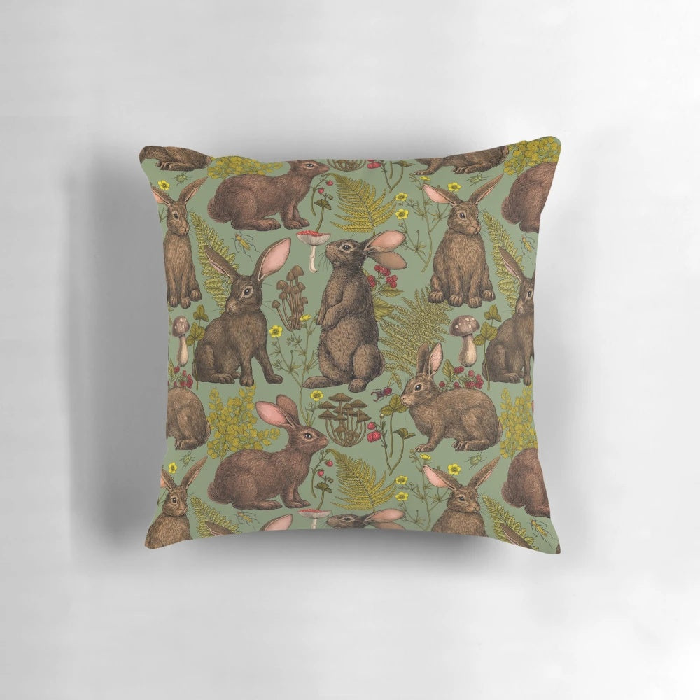 A cozy pillow featuring a beautiful illustration of rabbits, ferns, and other woodland flora