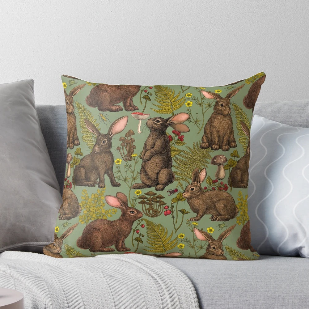 A cozy pillow featuring a beautiful illustration of rabbits, ferns, and other woodland flora