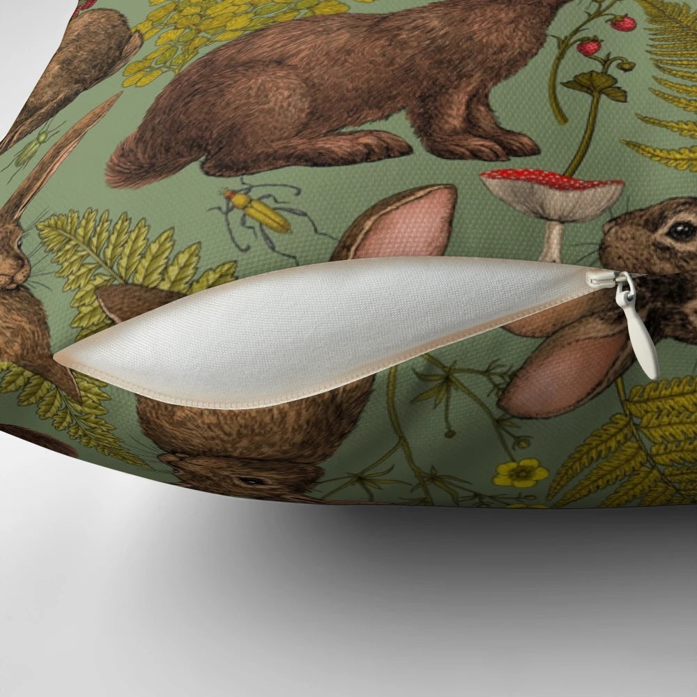 A cozy pillow featuring a beautiful illustration of rabbits, ferns, and other woodland flora