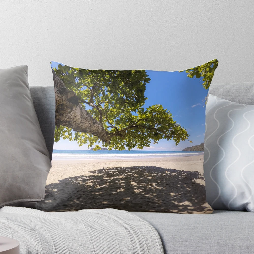 A shady spot on a tropical beach pillow, featuring lush greenery and a serene ocean view.
