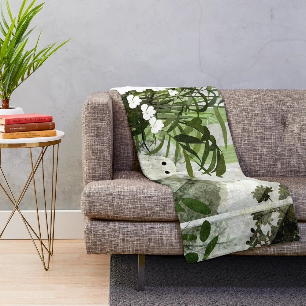 Plush blanket with ghostly greenhouse design, featuring nature elements and a whimsical, vintage-inspired style.