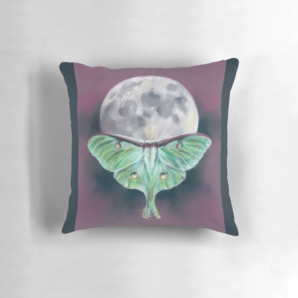 Soft pastel artwork of a luna moth on a background of a full moon, featured on a plush decorative pillow.