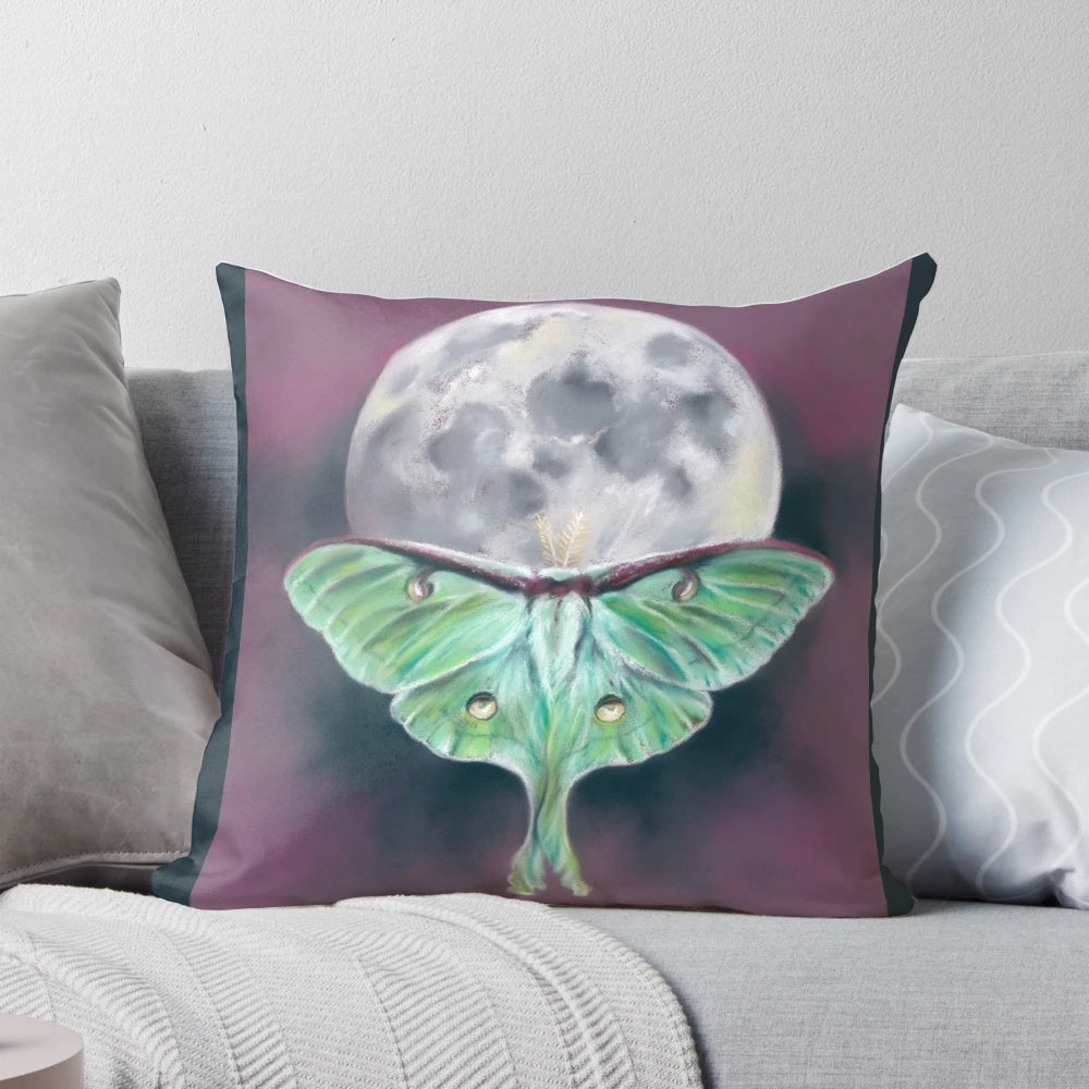 Soft pastel artwork of a luna moth on a background of a full moon, featured on a plush decorative pillow.