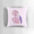 Closeup of a pastel skull-shaped pillow adorned with delicate, ethereal flowers against a dark, nature-inspired background.