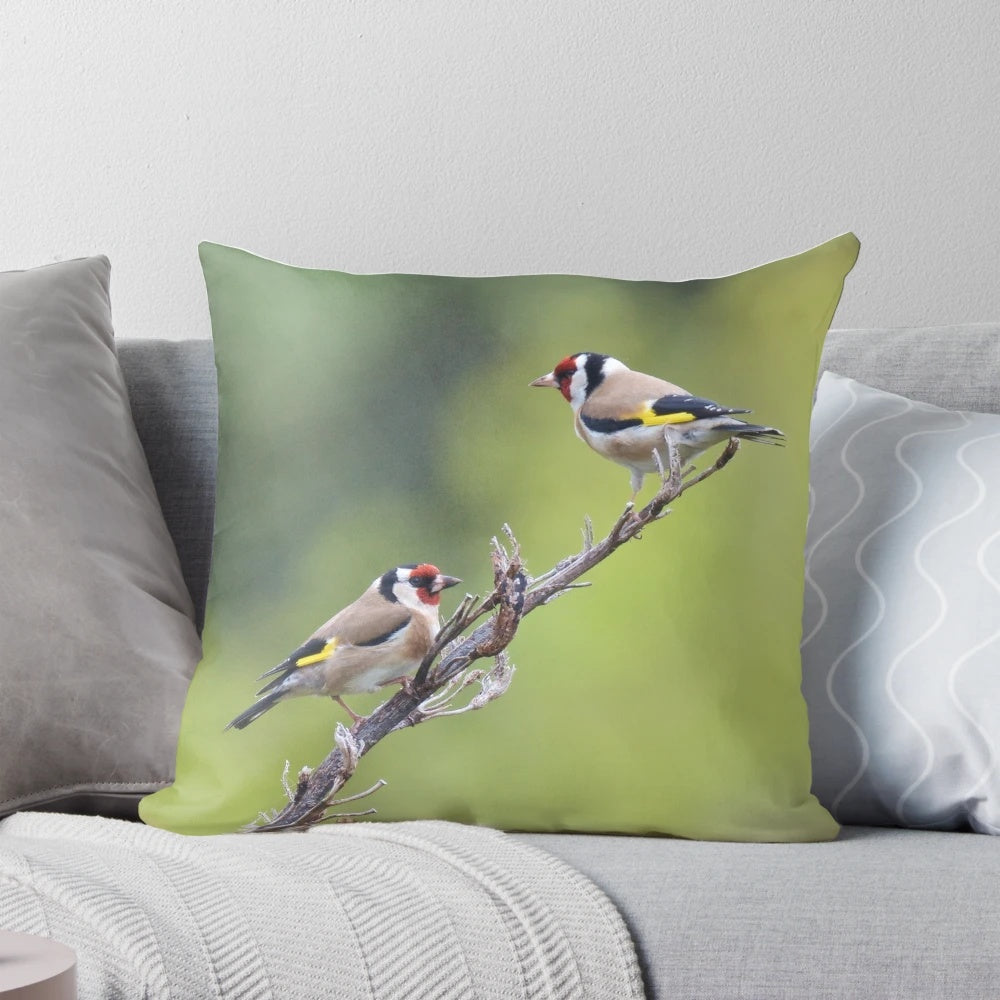 Photograph of a decorative pillow featuring a European goldfinch bird illustration by artist David Irwin.