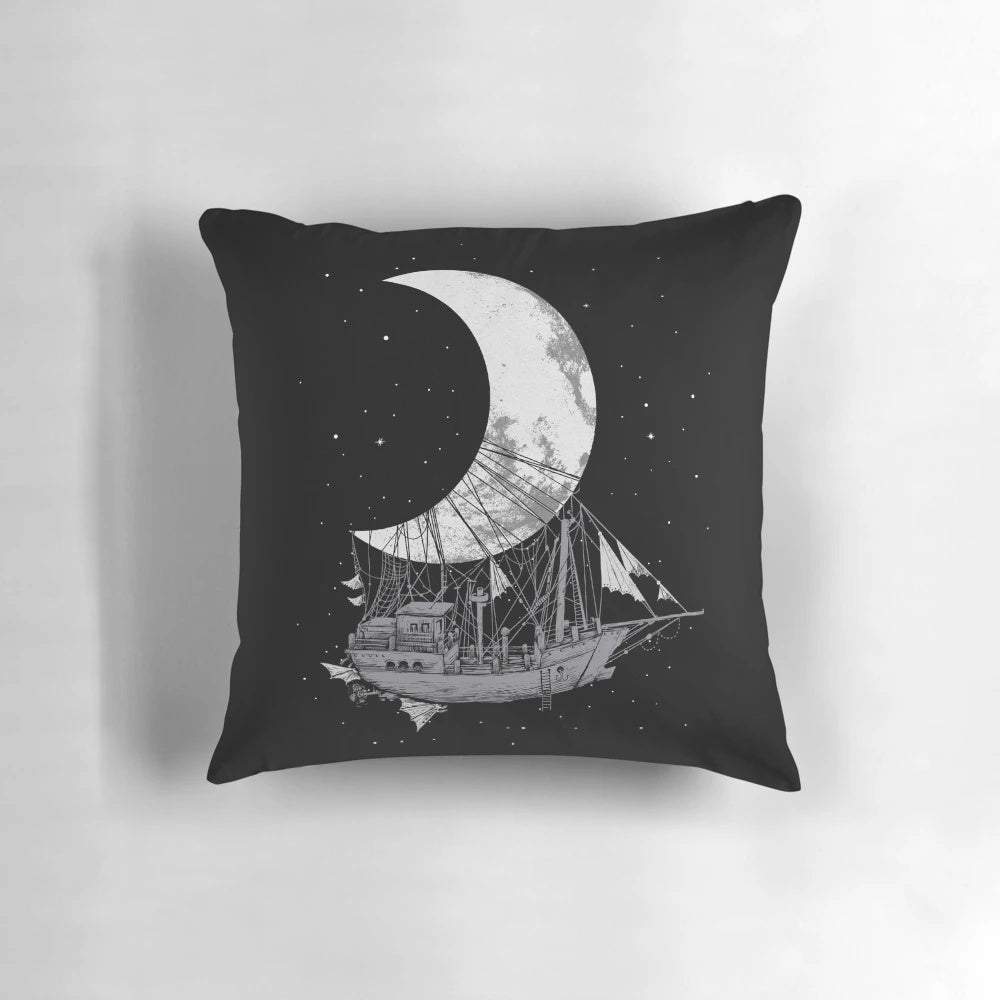 A stylish black and white pillow featuring a crescent moon and space ship design, perfect for adding a touch of adventure and fantasy to any room.