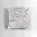 Closeup of a beautifully crafted beaded decorative pillow with lace, tulle, and confetti accents