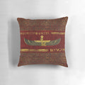 Golden Egyptian god ornament on a rich, red leather pillow