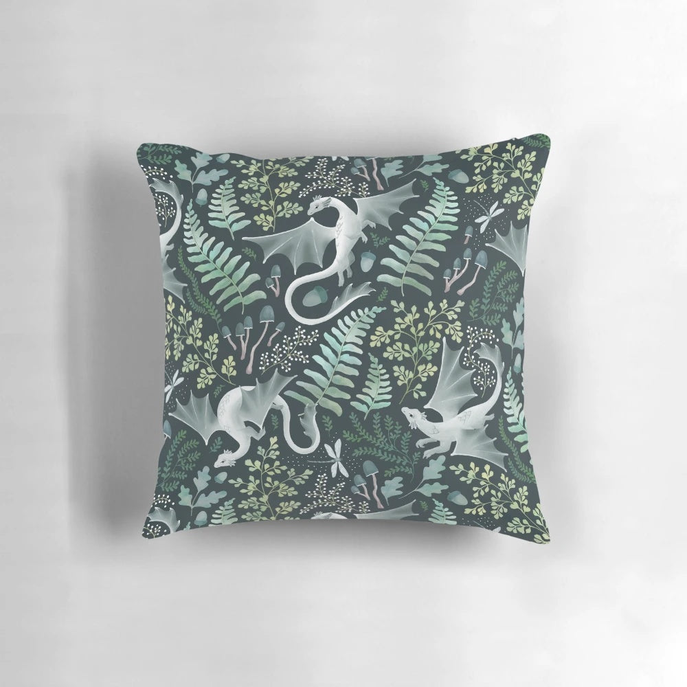A decorative throw pillow featuring a whimsical forest dragon design in shades of green on a dark green background, perfect for nature-inspired home decor.