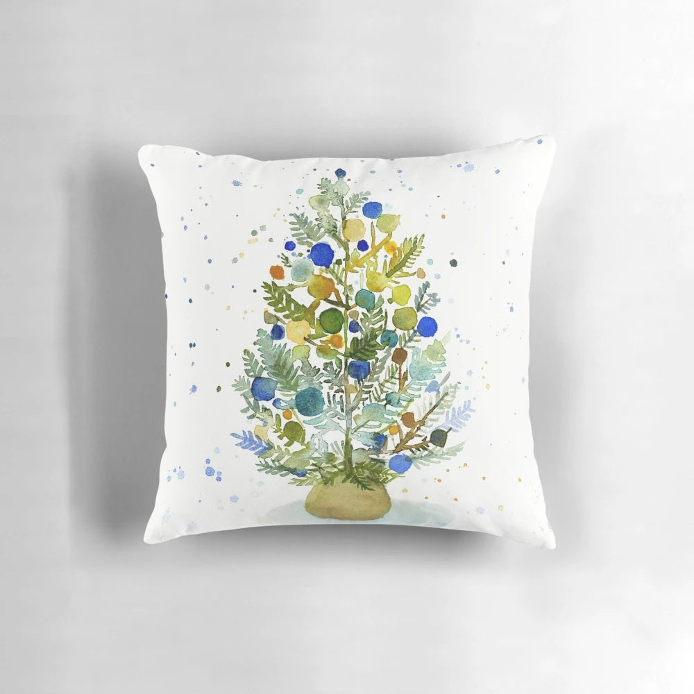 Farmhouse-style watercolor painting of a Christmas tree in blue, green, and earth tones on a cozy throw pillow.