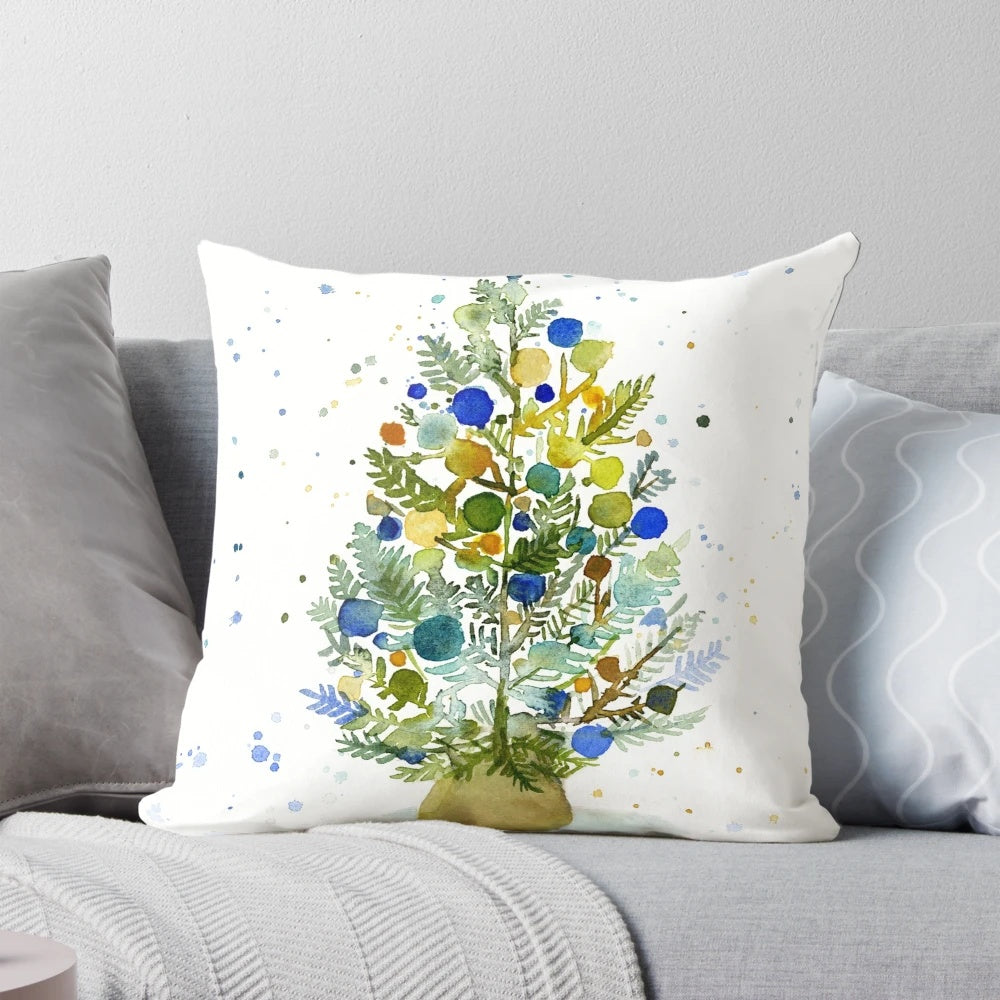 Farmhouse-style watercolor painting of a Christmas tree in blue, green, and earth tones on a cozy throw pillow.