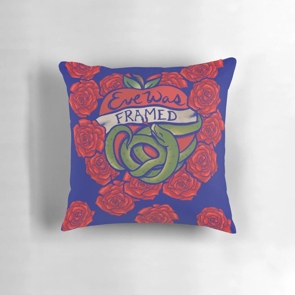 Decorative throw pillow with "Eve Was Framed" text and biblical Garden of Eden design, featuring feminist and Christian themes.