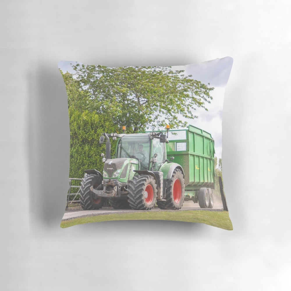 Fendt tractor pulling a silage trailer in a lush green countryside field