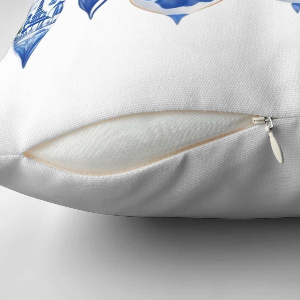 Blue and white chinoiserie-style Christmas pillow with pine branches, berries, and a bow