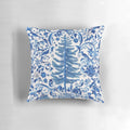 Decorative blue chinoiserie-style Christmas pillow with pine branches, berries, and a bow