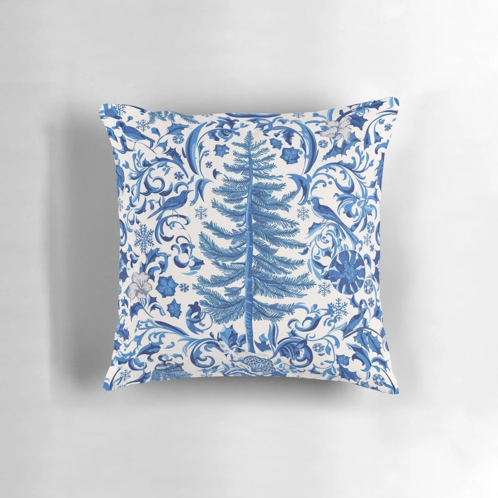 Decorative blue chinoiserie-style Christmas pillow with pine branches, berries, and a bow