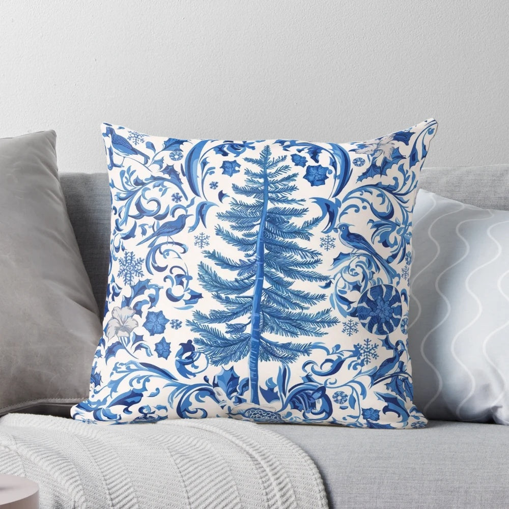 Decorative blue chinoiserie-style Christmas pillow with pine branches, berries, and a bow