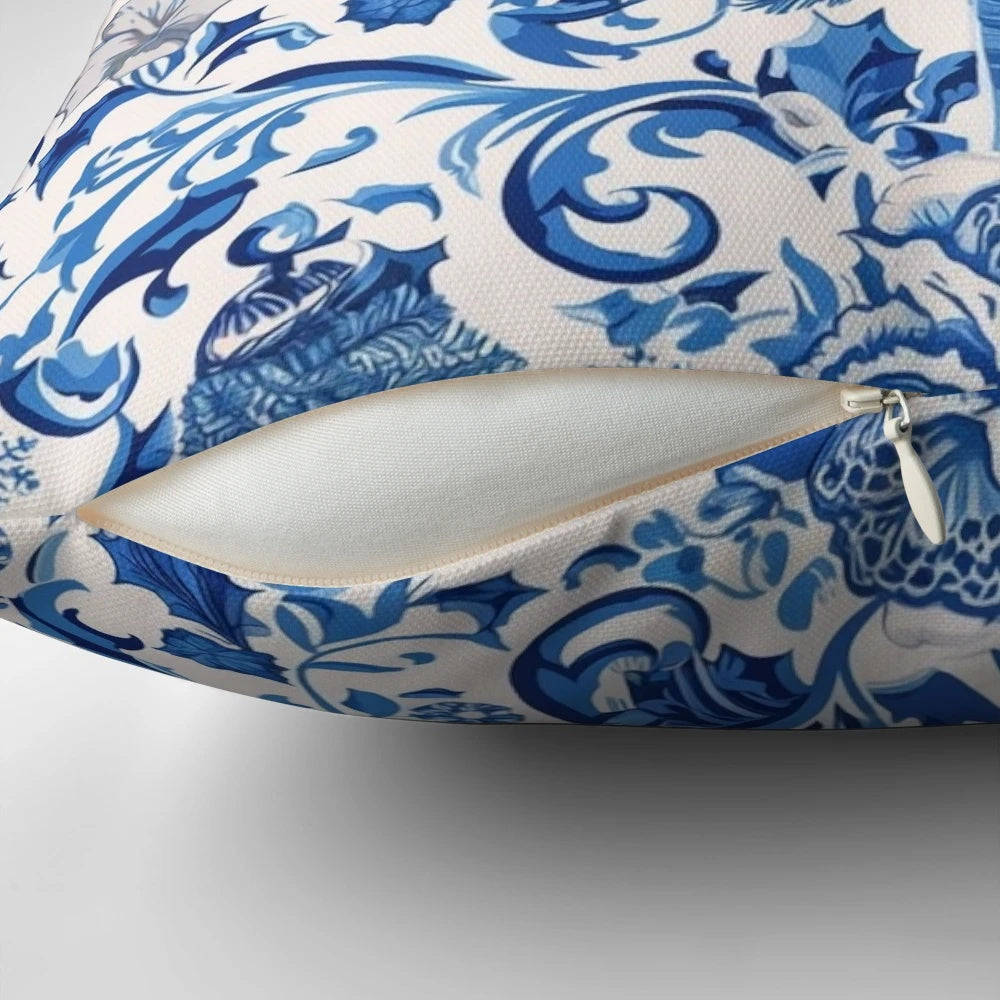 Decorative blue chinoiserie-style Christmas pillow with pine branches, berries, and a bow